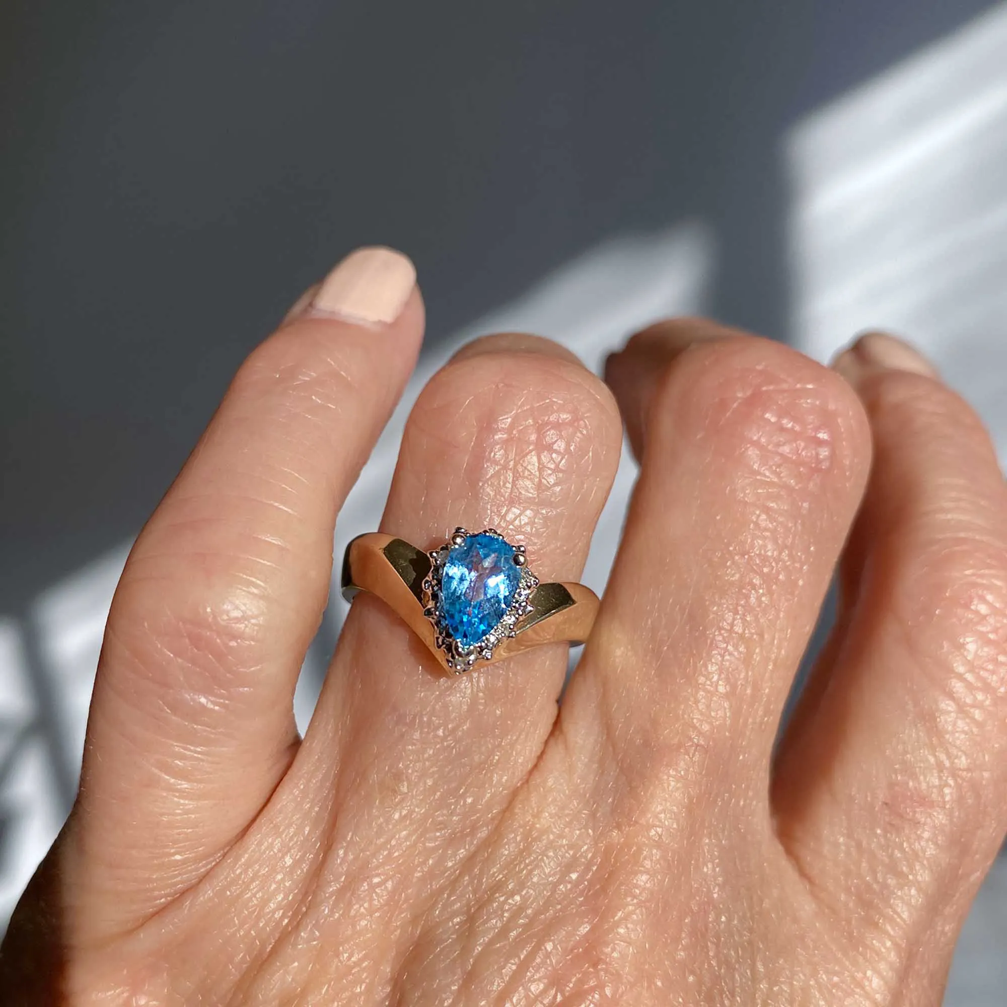 Diamond Halo Pear Cut Blue Topaz Ring in Gold